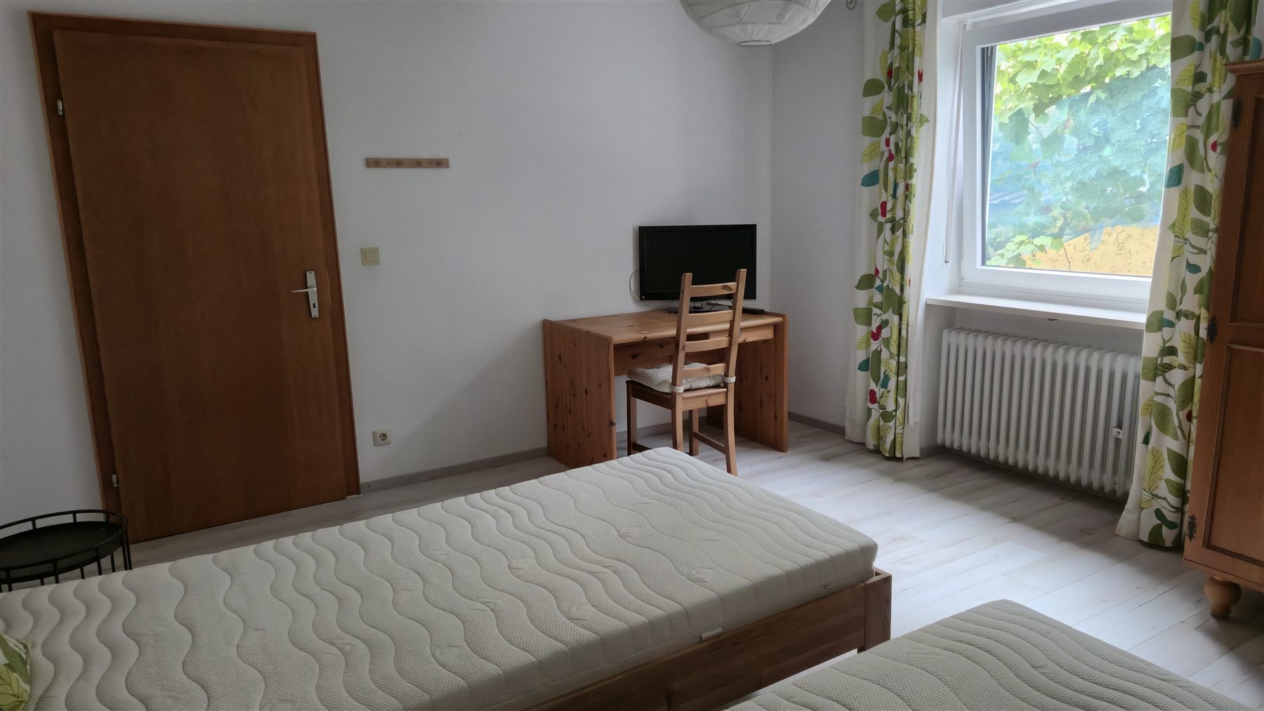 Pensionszimmer mit Schreibtisch und TV
