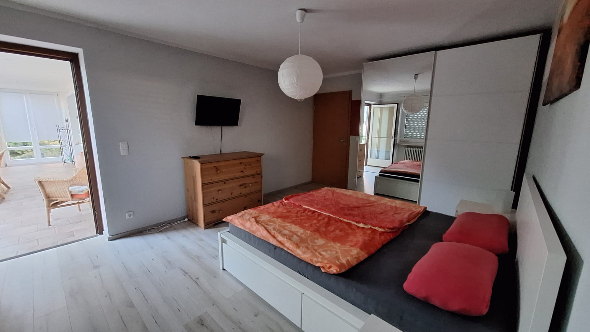 Schlafzimmer mit TV und Zugang zum Wintergarten